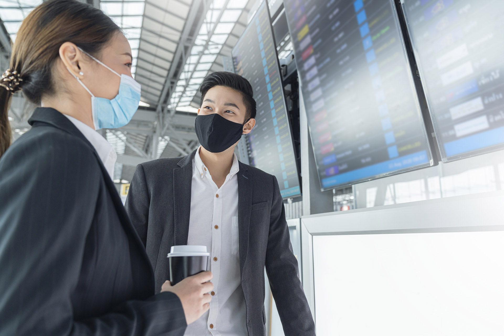 travellers wearing face masks at the airport