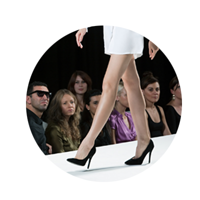 Circular Image of a Model on a catwalk with high heels and a white dress
