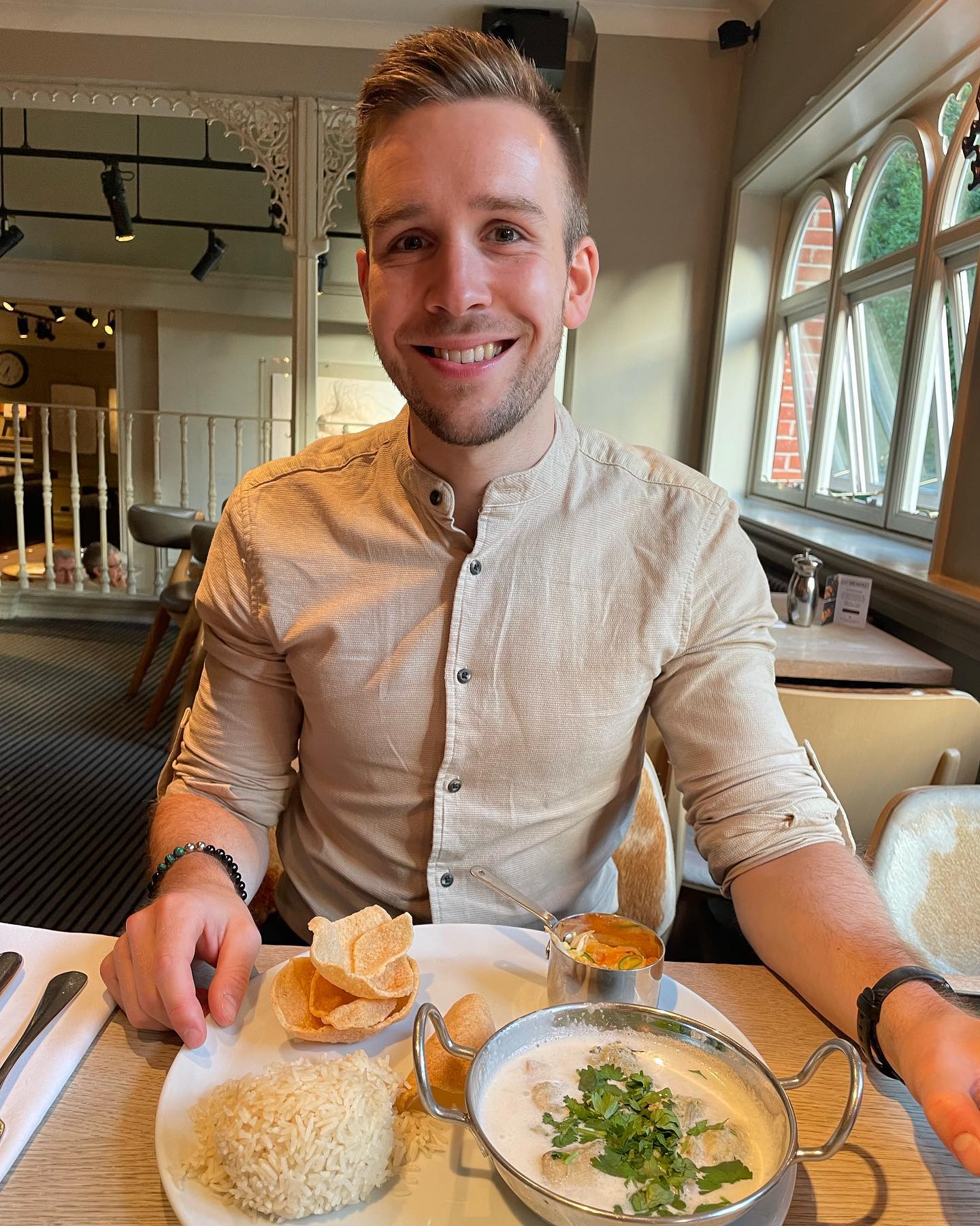 Photos of Callum at a meal eating a curry