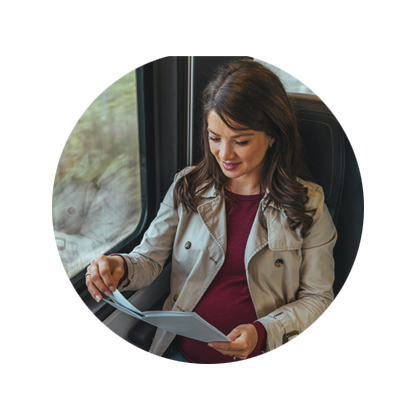 Female lawyer sitting on a train smiling and studying paperwork 