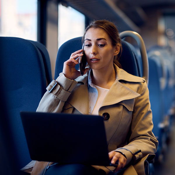 Young businesswoman talking on the ohone while sitting on a train