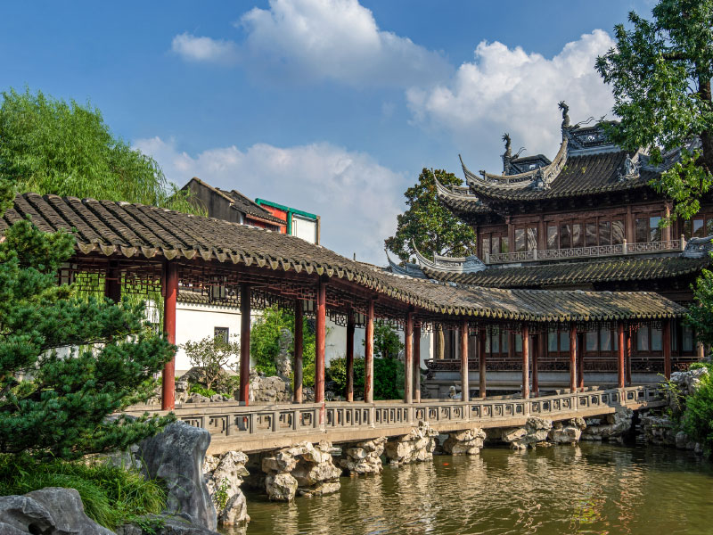Traditional Chinese buildings and a pond at the You Yuan Gardens in Shanghai, China.
