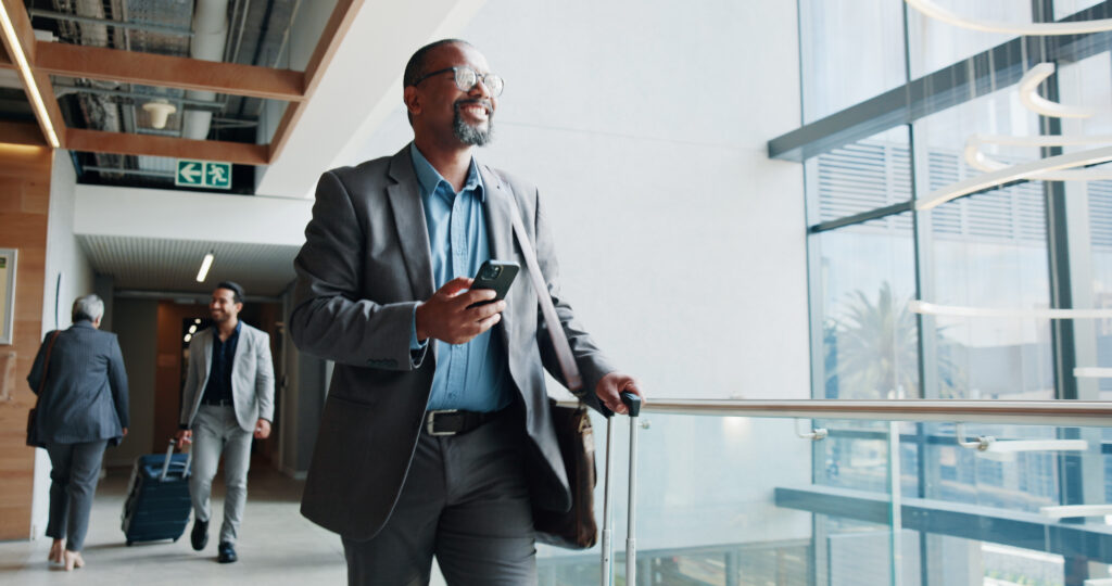 Happy, businessman and walking with phone or suitcase for travel, job opportunity or career trip at airport. Man, employee or traveler with smile, mobile smartphone or luggage for commute or flight Happy traveller