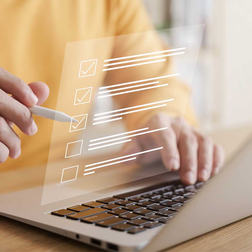 A woman at a laptop using a digital checklist