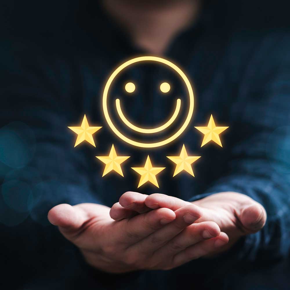 Representation of an employee review with a holographic smiley face and 5 stars hovering above hands<br />
