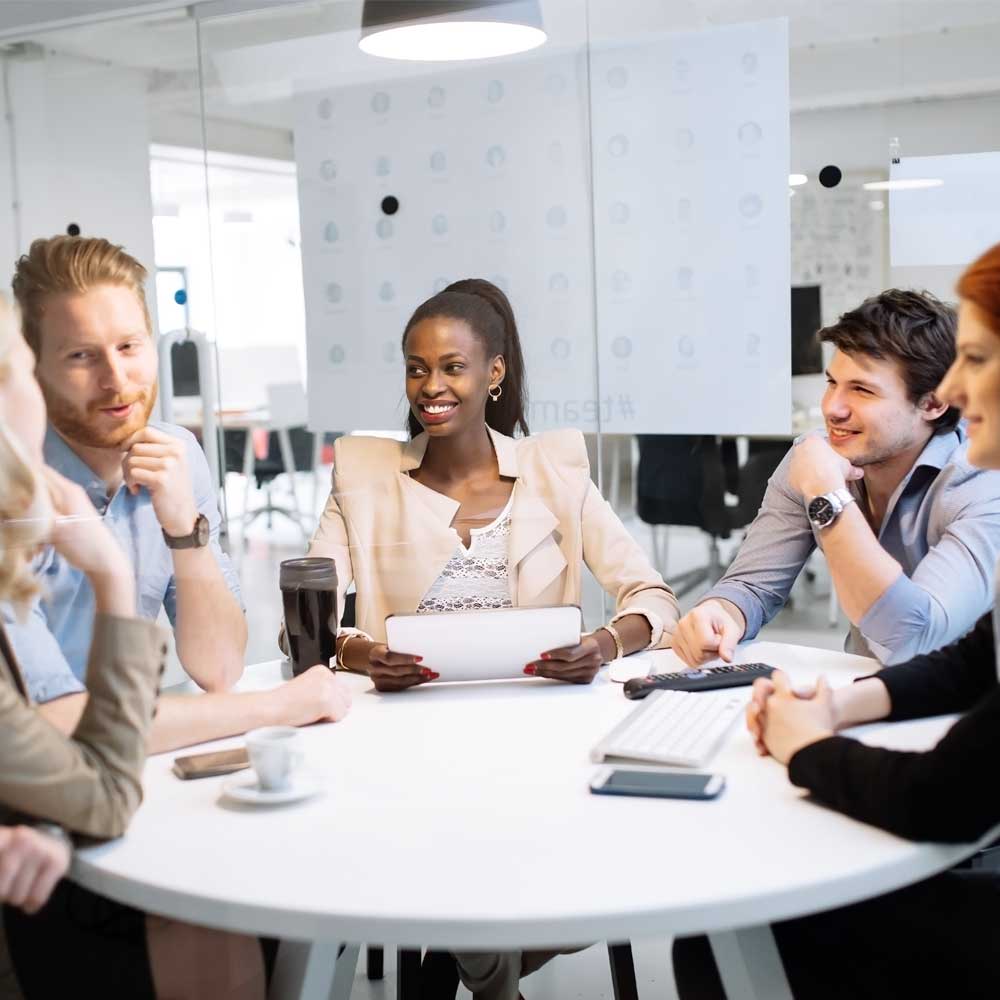 a team of businesspeople in casual office sitting around a table having. meeting
