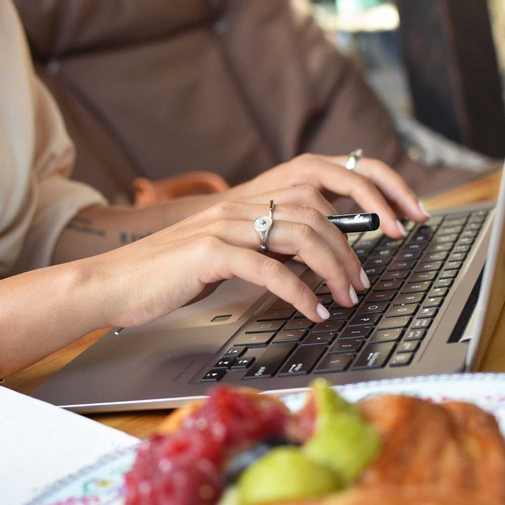 A female staff memeber using a laptop to write a document<br />
