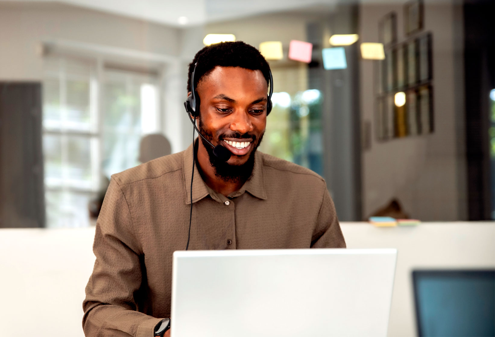Black male wearing a headset as he talks to a customer